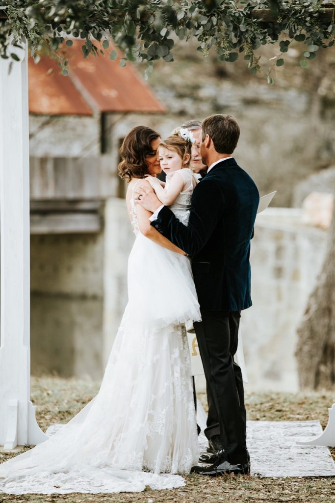 Nice shot of a Bride and a Groom and a little girl, all at a wedding ceremony in Eagle Dance Ranch.