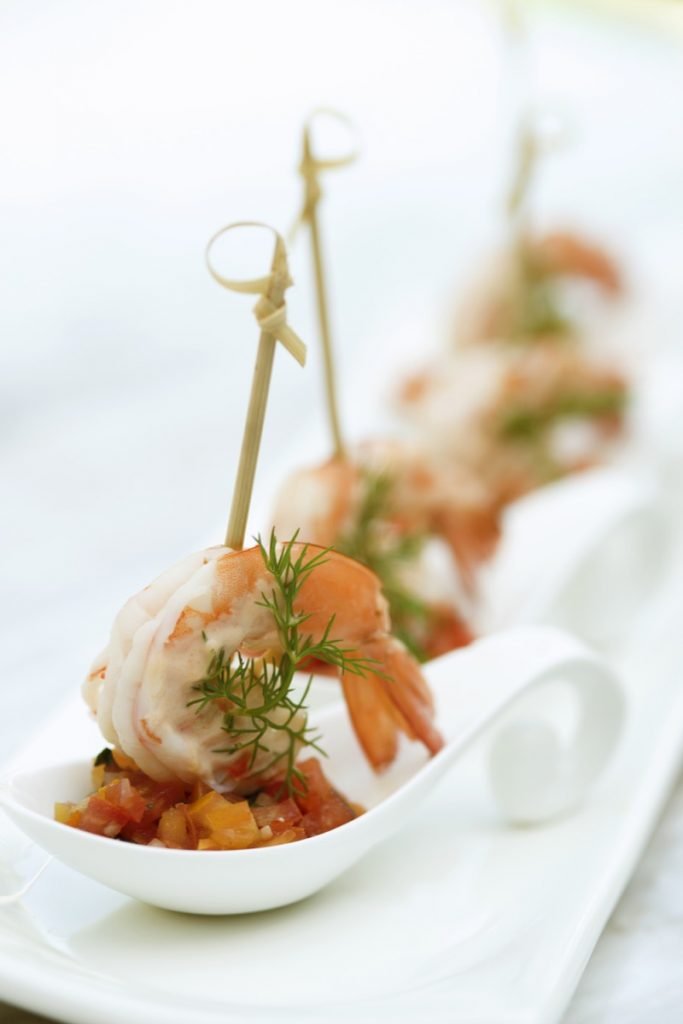 Absolutely-Delicious shows a close-up of shrimp skewered onto a plate of relish.
