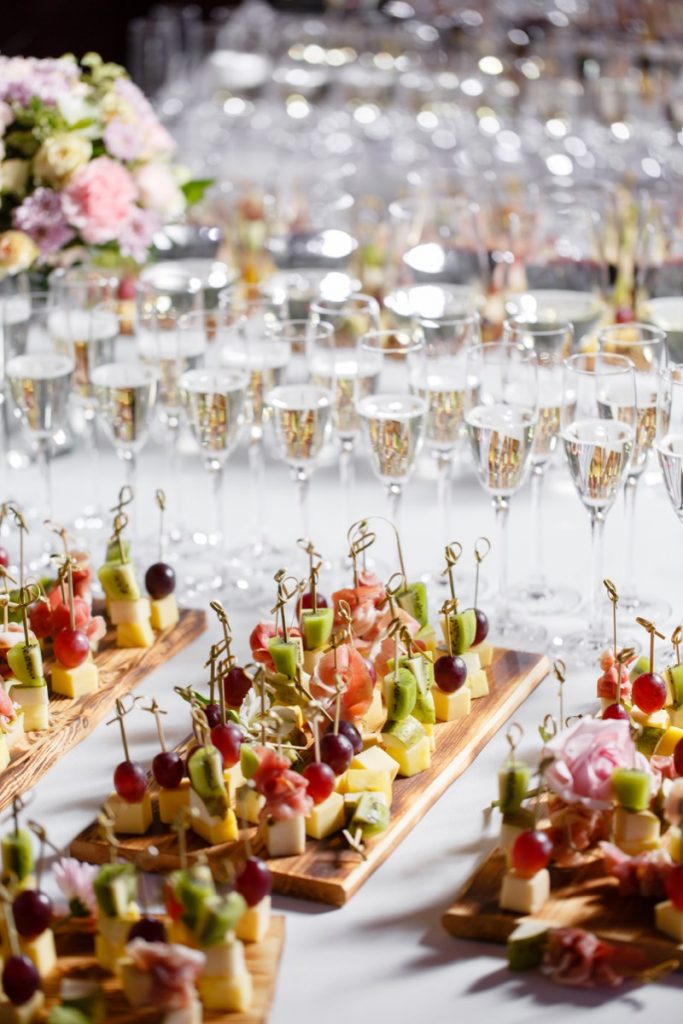 Absolutely-Delicious reception buffet with an assortment of canapes with drinks in the backround.