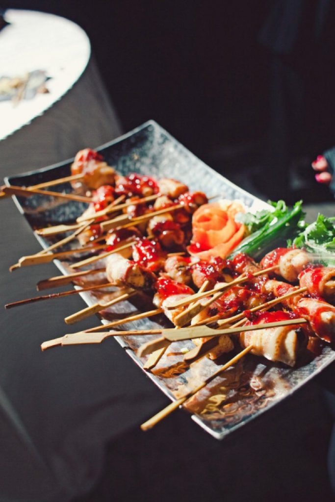 Absolutely Delicious close-up of bacon wrapped chicken kabobs on a plate.