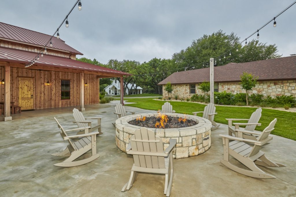 An outdoor porch with a large round fire at The Chandelier of Gruene.