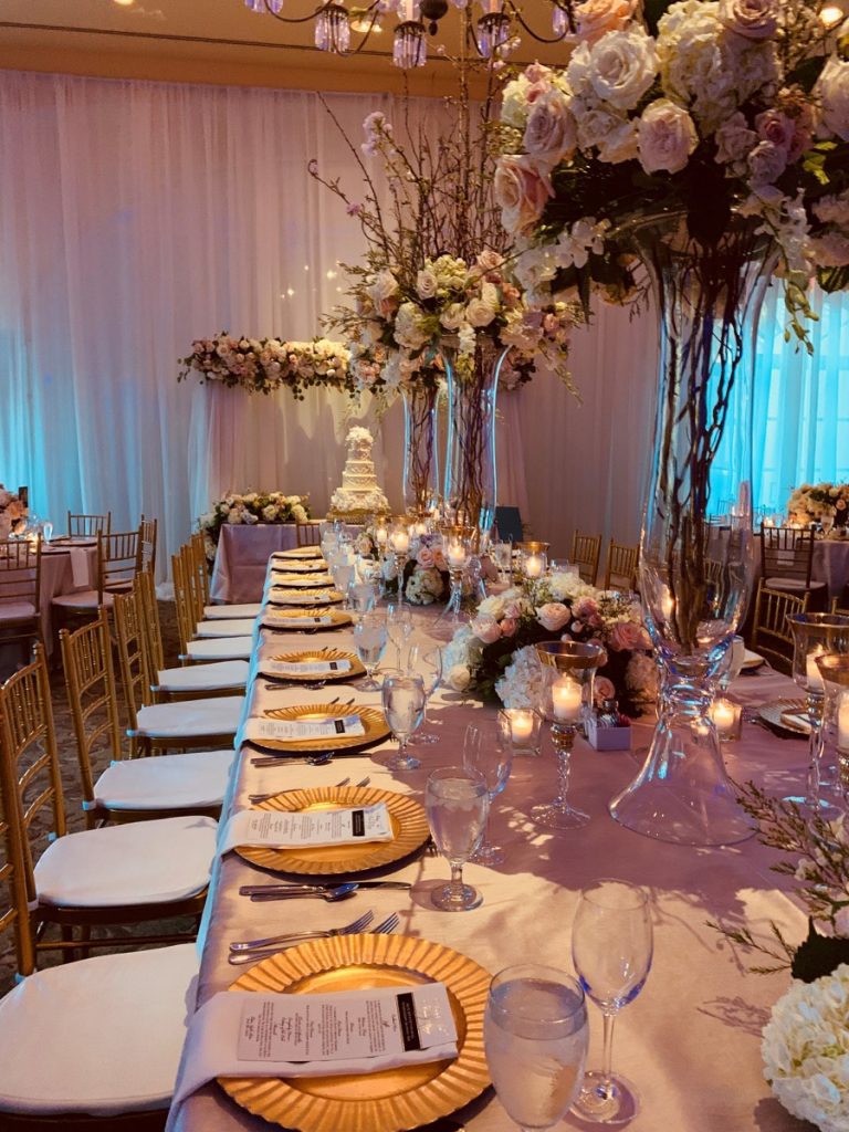 A long bridal party table is truly made better with these centerpieces of bouquets and centerpieces by Events by A Touch of Elegance!