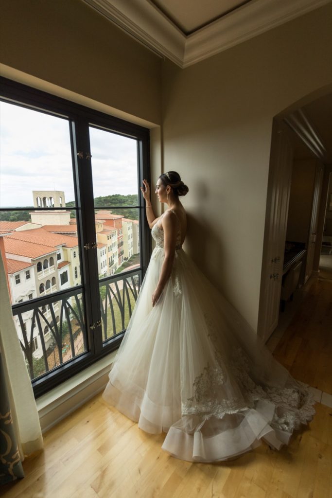 This model bride looks pensivly out a very large window to the shops below The Eilan Hotel Resort and Spa.