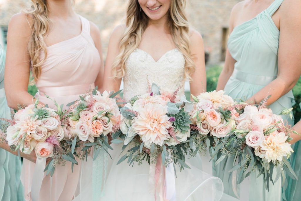 An assembly of a bride with her bridesmaids with Freesia Designs bouquets!