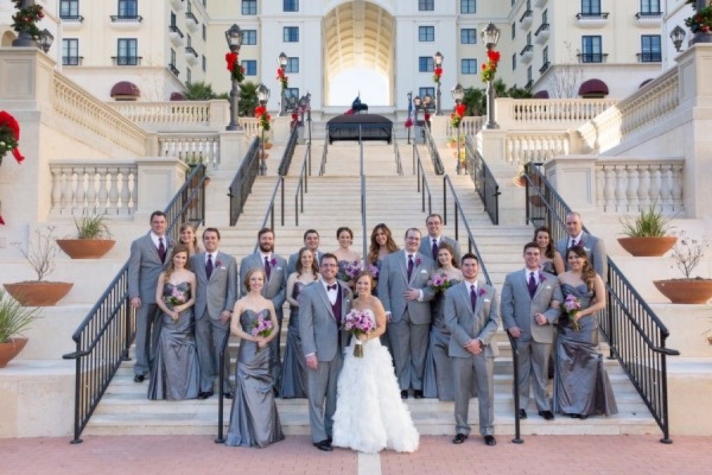 The wdding party and Bride and groom all gathered at the foot of the stairs for a The Eilan Hotel Resort and Spa picture.