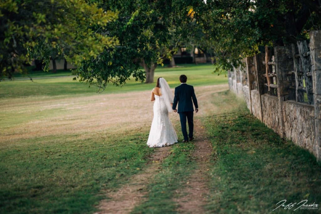 A bride and groom walking on a path around Fair Oaks Ranch Golf and Country Club