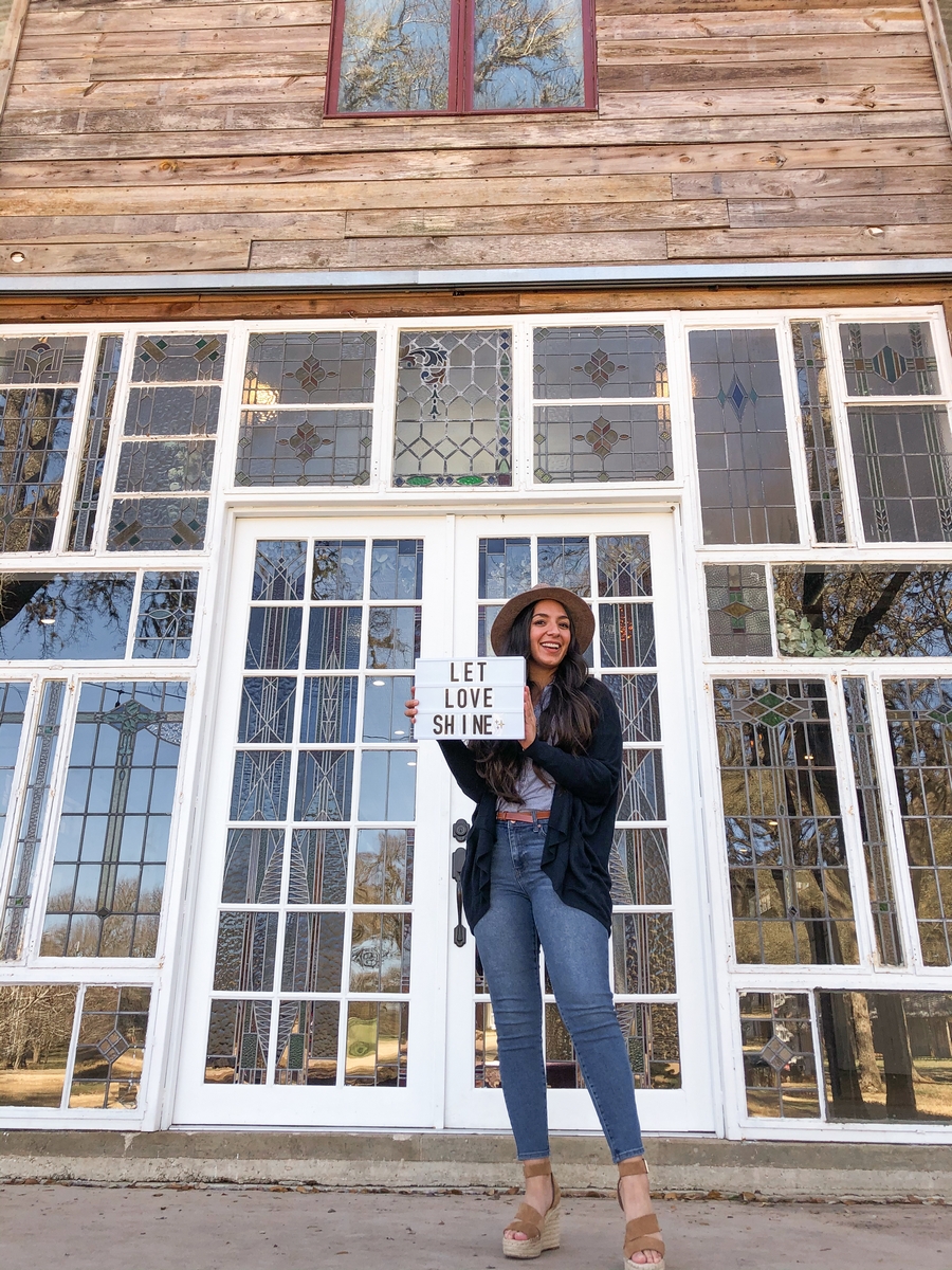 Erika posing in front of Harper Hill Ranch Stained glass windows