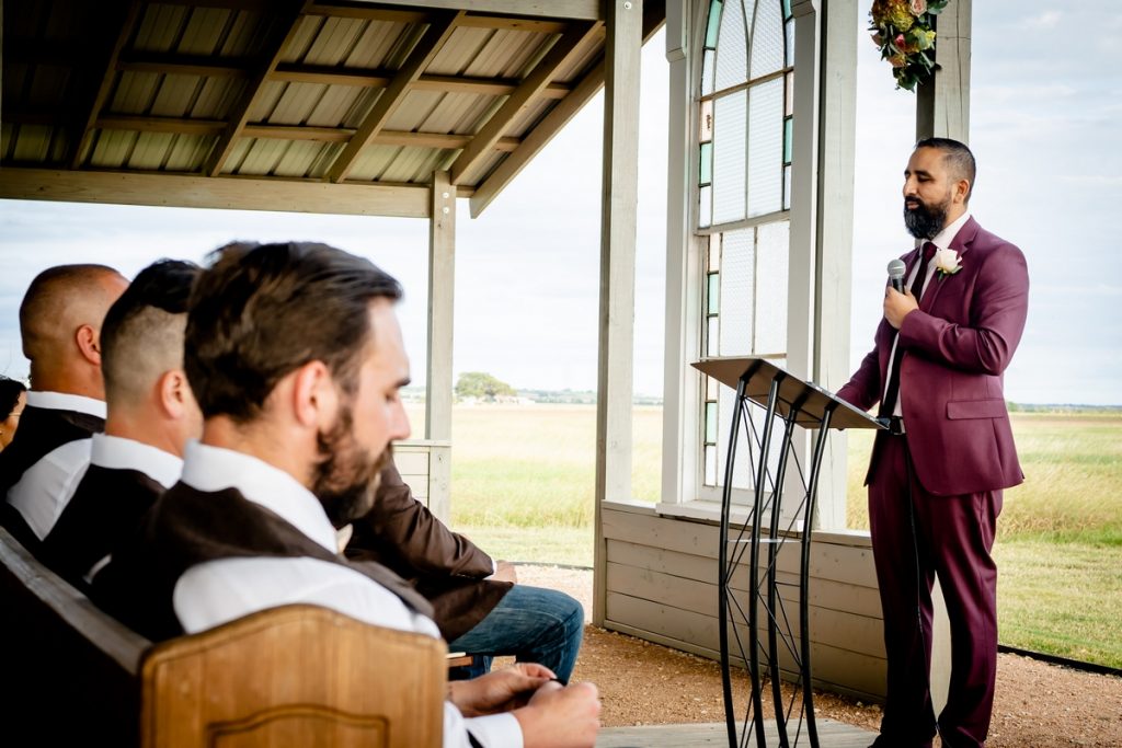 Father officiating wedding in maroon suit