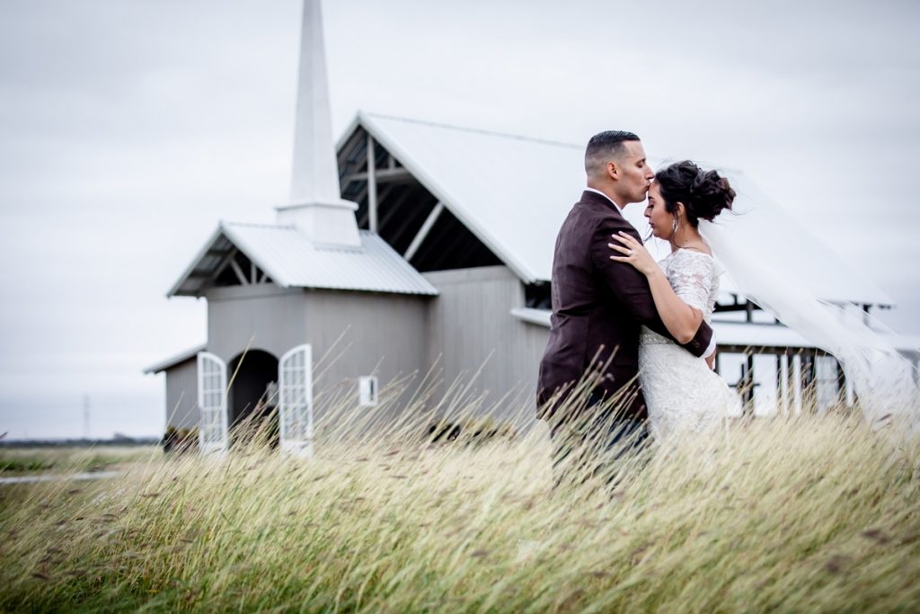 Man and woman embrace in front of wedding venue