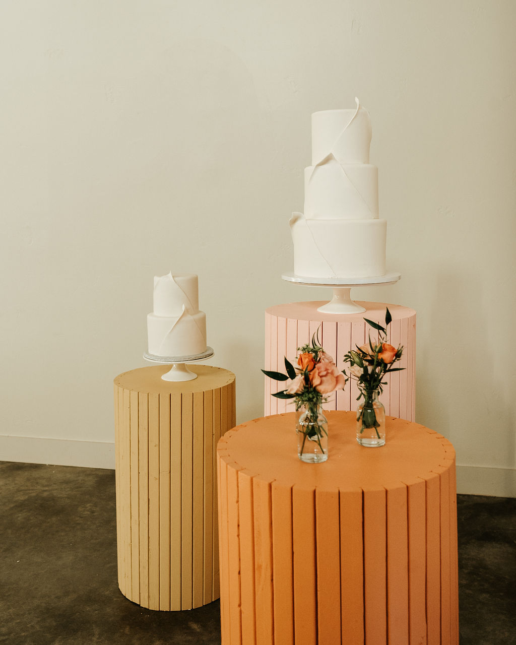 tiered wedding cakes on colorful stands